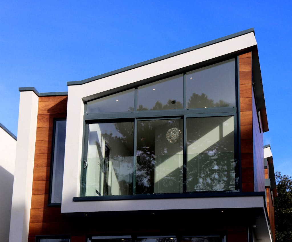 Contemporary house in Poole, UK featuring a sleek design with large glass windows and wood paneling.